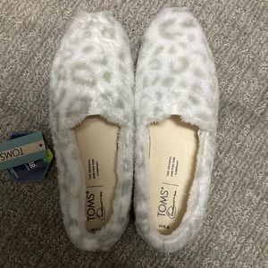 Black and white furry TOMs. Never been worn. Soft material.
